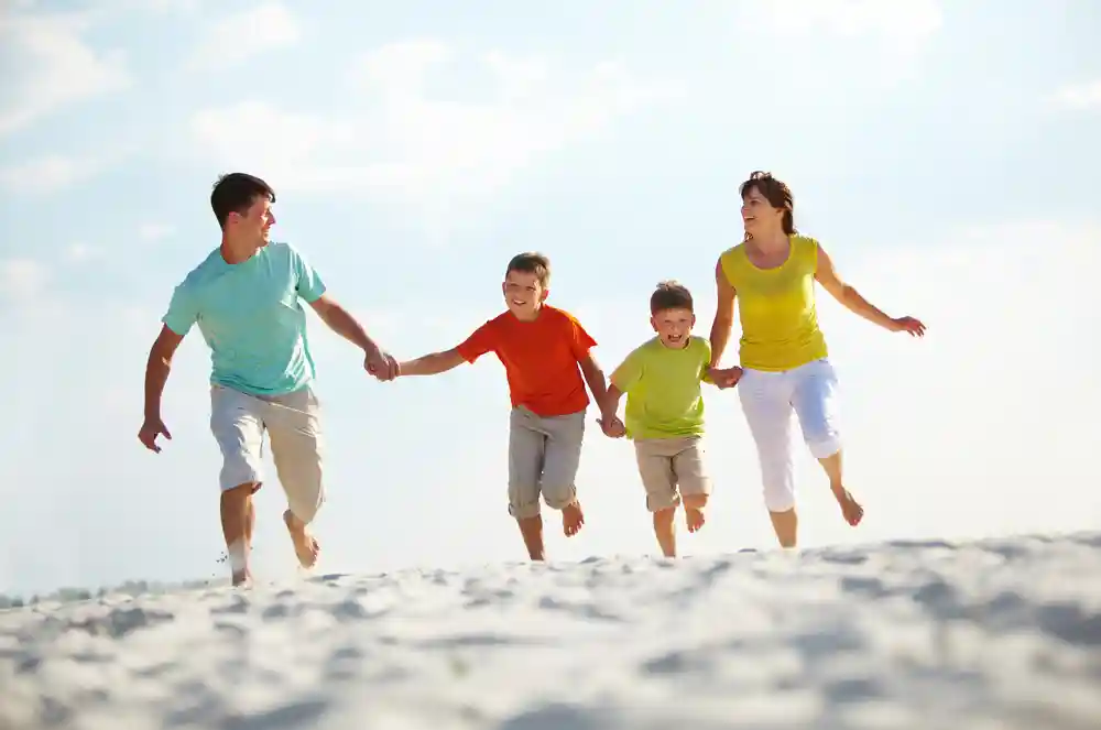 Family Protection Investments - Couple and family playing on beach